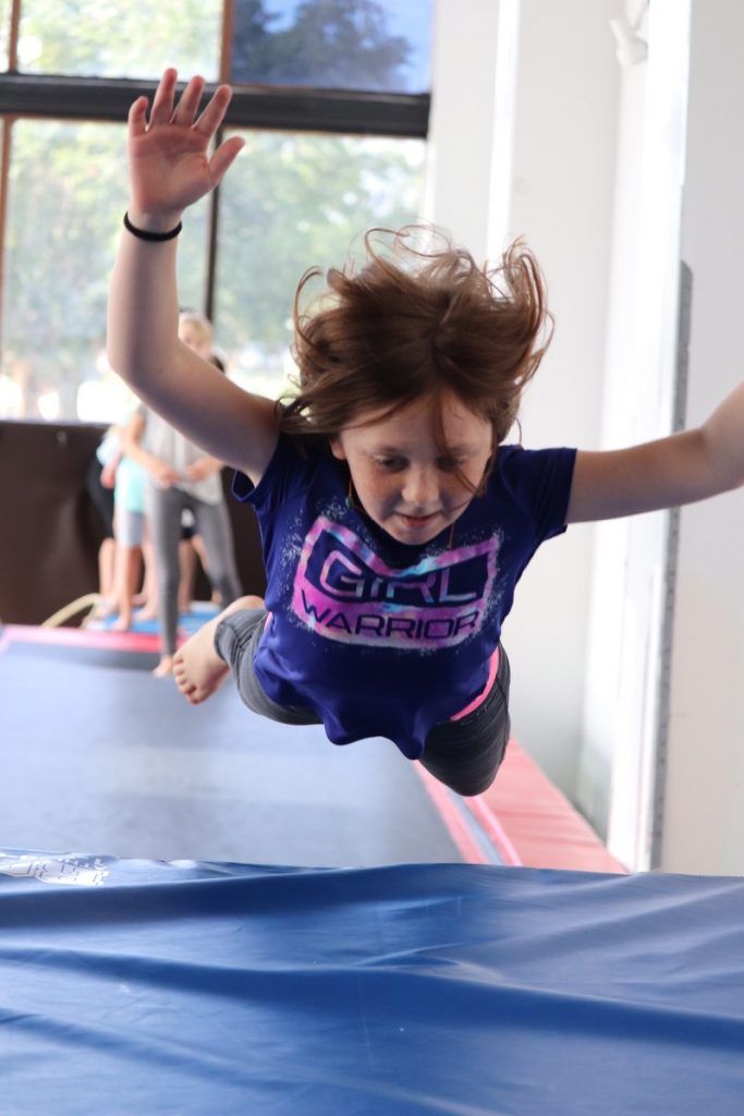Young camper leaping onto a mat at Orlando circus camp